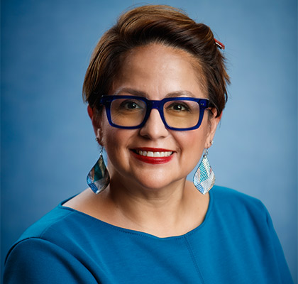 Professional portrait of Tracy Almanzan in blue shirt